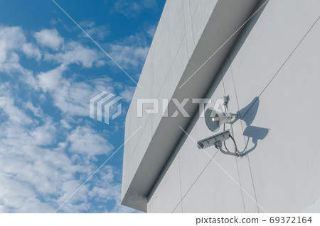 Loudspeakers and CCTV security cameras observation on a wall of a building Loudspeakers and CCTV security cameras observation on a wall of a building 69372164