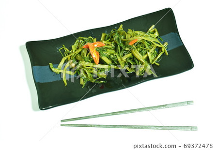 stir fried morning glory with chili on plate and Korean stainless chopsticks in white background stir fried morning glory with chili on plate and Korean stainless chopsticks in white background 69372478