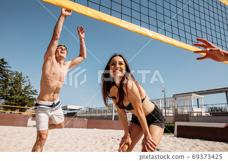 Summertime beach volleyball game in progress Summertime beach volleyball game in progress 69373425