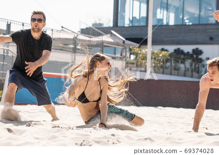 Carefree young people having fun and jumping on the seaside court. Carefree young people having fun and jumping on the seaside court. 69374028
