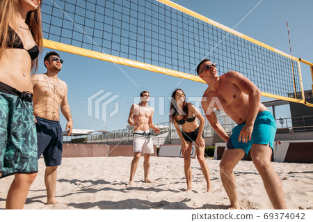 Summertime beach volleyball game in progress Summertime beach volleyball game in progress 69374042