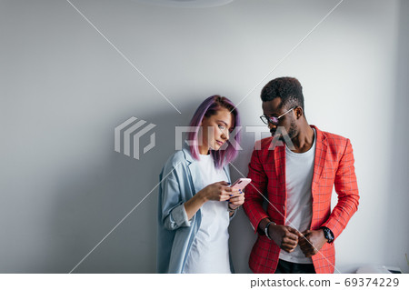 Portrait of happy multiracial couple isolated over gray wall background, copy space. Portrait of happy multiracial couple isolated over gray wall background, copy space. 69374229