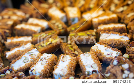 Traditional Turkish dessert kadayif. Shredded dough baked in syr Traditional Turkish dessert kadayif. Shredded dough baked in syr 69374238