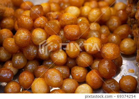 Traditional Turkish  Lokma dessert fryied in oil and sweetened w 69374254