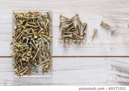 Group of Screw bolts on wooden background. 69375202