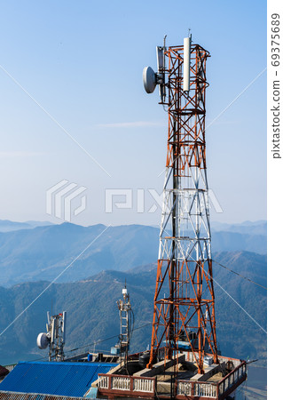 Telecommunication tower with mountains on background 69375689