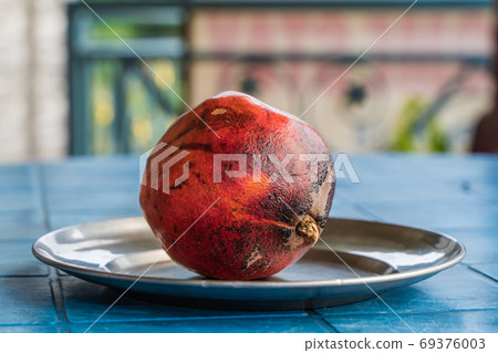 One Pomegranate on a Plate, Stock Photo One Pomegranate on a Plate, Stock Photo 69376003