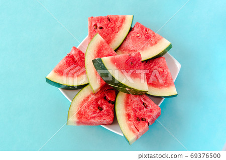 Water melon slices on a plate on blue background 69376500
