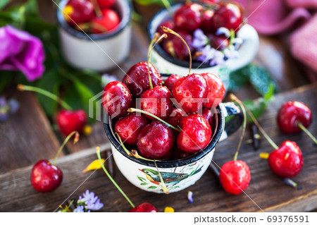 Fresh ripe cherries in a mug on summer background Fresh ripe cherries in a mug on summer background 69376591