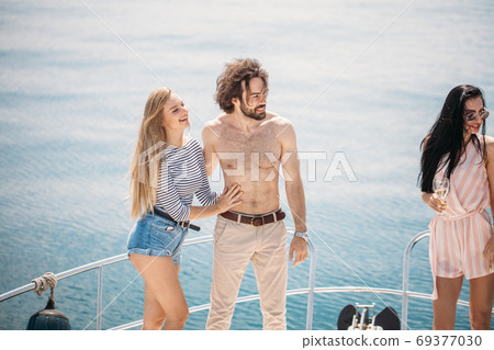 Marine cruise and vacation - youngsters with champagne glasses on boat or yacht 69377030