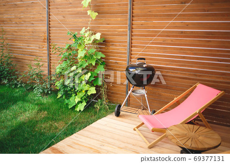 recreation area in the yard of the house: chairs, barbecue, table 69377131