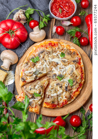 Homemade pizza with tomatoes, mushrooms and green basil. Homemade pizza with tomatoes, mushrooms and green basil. 69377244