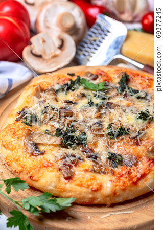Homemade pizza with mozzarella, mushrooms and spinach. Homemade pizza with mozzarella, mushrooms and spinach. 69377245