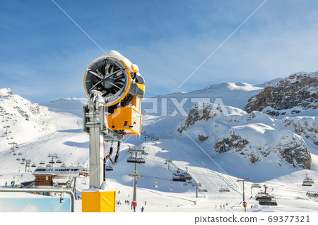 Artificial Snow cannon near piste.Ski lift ropeway Artificial Snow cannon near piste.Ski lift ropeway 69377321
