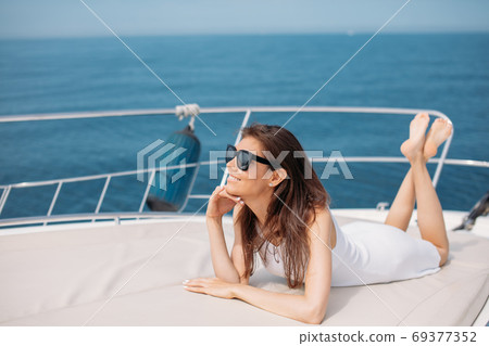 Young sexy woman on her private yacht at sunset Young sexy woman on her private yacht at sunset 69377352