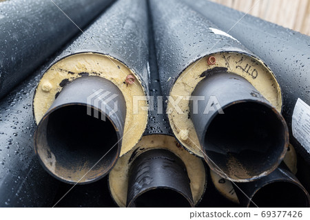 Heap of many new black insulated steel pipes at Heap of many new black insulated steel pipes at 69377426