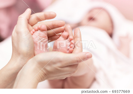 Mother holding newborn baby feet in hands. Mom Mother holding newborn baby feet in hands. Mom 69377669