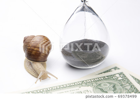 snail next to the hourglass and dollars on a white background. s snail next to the hourglass and dollars on a white background. s 69378499