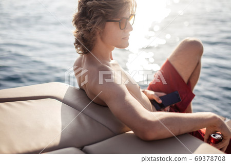 Young caucasian hipster guy enjoying journey on yacht deck sailing the sea. Young caucasian hipster guy enjoying journey on yacht deck sailing the sea. 69378708