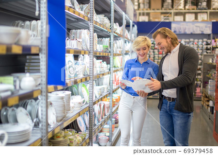 Couple choosing household goods in retailer. Consumerism, shopping, lifestyle. 69379458