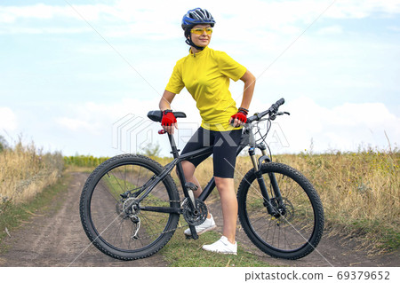 Beautiful girl cyclist with a bicycle on the nature. Healthy lif 69379652