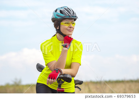 Beautiful girl cyclist with a bicycle on the nature. Healthy lif 69379653