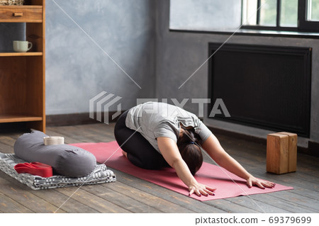 Woman doing forward bend yoga exercise, Balasana, Child Pose, stretching spin Woman doing forward bend yoga exercise, Balasana, Child Pose, stretching spin 69379699