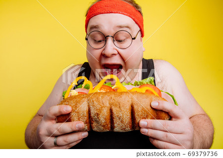 fat man eating fast food hamberger fat man eating fast food hamberger 69379736