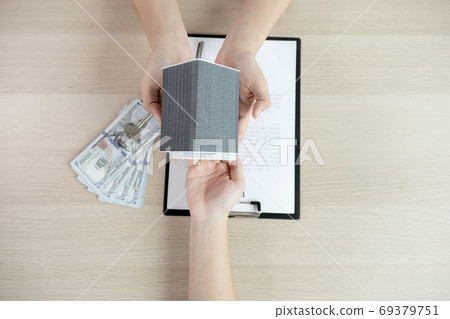 Hand a real estate agent, hold the home model, and explain the business contract Hand a real estate agent, hold the home model, and explain the business contract 69379751