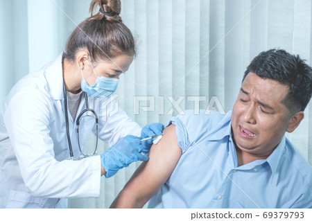 The doctor's hand holding a syringe and was about to vaccinate a patient in the clinic 69379793