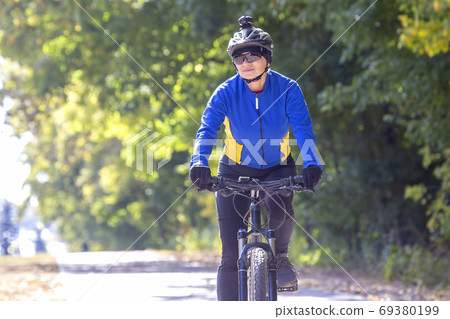 Beautiful girl cyclist rides a bicycle. Healthy lifestyle and sp Beautiful girl cyclist rides a bicycle. Healthy lifestyle and sp 69380199