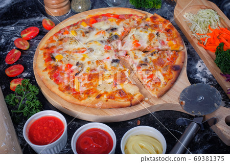 Pizza ham,mushrooms, tomatoes and cheese. on a Black table with Pizza ham,mushrooms, tomatoes and cheese. on a Black table with 69381375