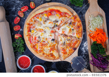 Pizza ham,mushrooms, tomatoes and cheese. on a Black table with Pizza ham,mushrooms, tomatoes and cheese. on a Black table with 69381376