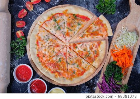 Salmon Seafood Pizza on a Black table with ingredients around Salmon Seafood Pizza on a Black table with ingredients around 69381378
