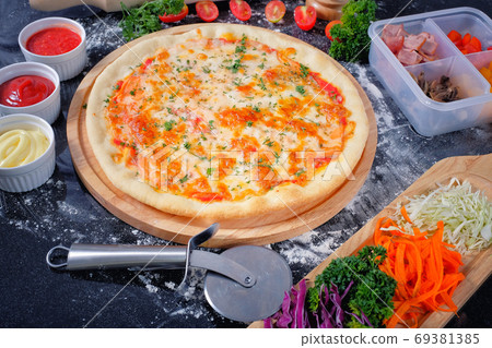 Salmon Seafood Pizza on a Black table with ingredients around Salmon Seafood Pizza on a Black table with ingredients around 69381385
