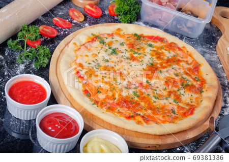 Salmon Seafood Pizza on a Black table with ingredients around Salmon Seafood Pizza on a Black table with ingredients around 69381386