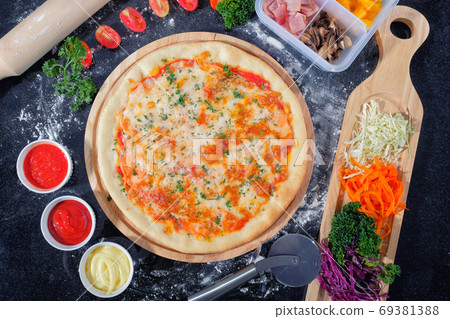 Salmon Seafood Pizza on a Black table with ingredients around Salmon Seafood Pizza on a Black table with ingredients around 69381388