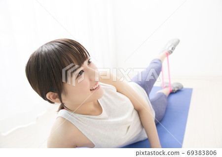 Woman training with a rubber band 69383806