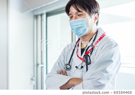 Doctor wearing a mask and examining 69384468