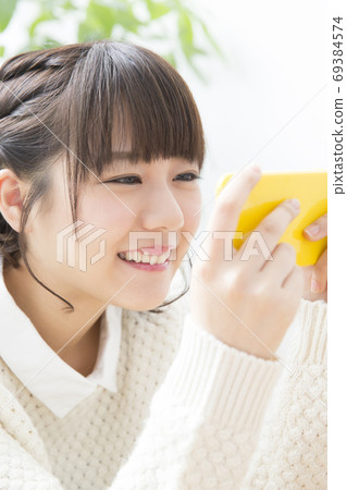 A woman watching a smartphone A woman watching a smartphone 69384574