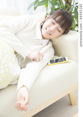 Woman snoozing on the couch 69385185