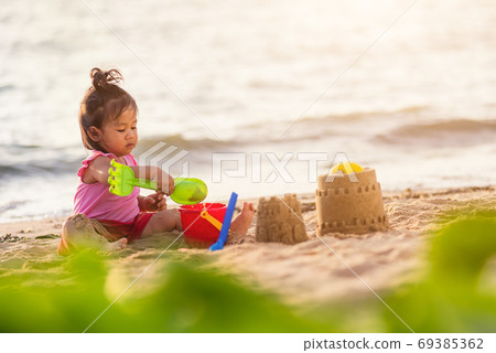 cute little girl playing sand with toy sand tools cute little girl playing sand with toy sand tools 69385362