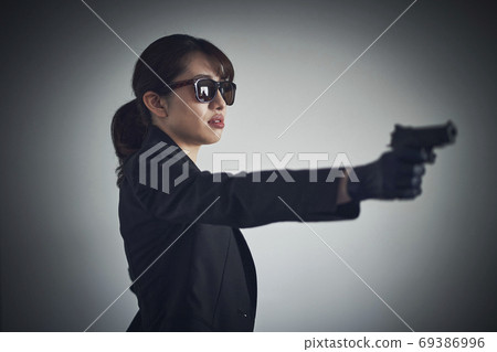 A woman with a gun 69386996