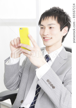 看智能手機的商人 69387214
