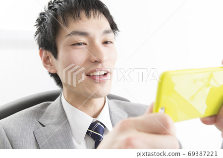 看智能手機的商人 69387221