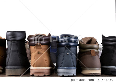 a lot of different shoes stand flush, the reverse side, in a row on a wooden board, concept, assortment of boots 69387839
