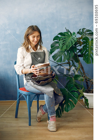 A young woman holds a ceramics dish in her hands 69388695