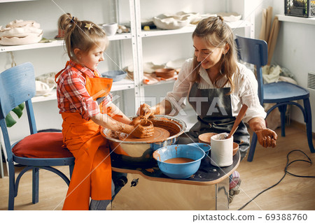 People making a vaze from a clay on a pottery's machine 69388760