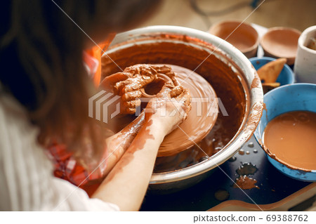People making a vaze from a clay on a pottery's machine 69388762
