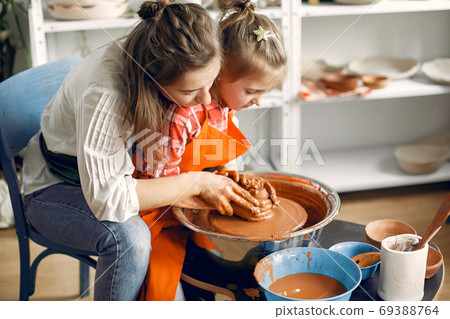 People making a vaze from a clay on a pottery's machine 69388764